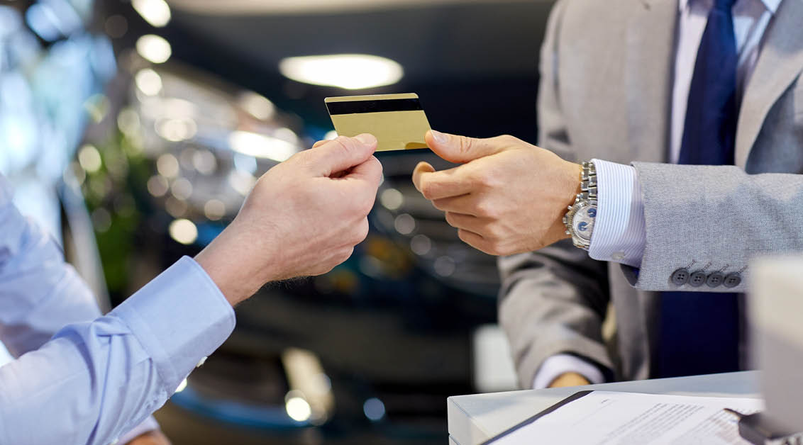 Frau übergibt einem Kunden eine Kreditkarte